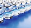 Concept for the availability of enough vaccine against the new corona virus SARS-CoV-2: Rows of glass container of vaccination. The word vaccination in English, Spanish, French and German on the label